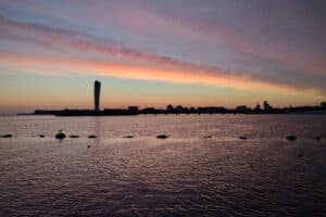 Camping i Malmö – Solnedgång över Öresund med tält och husbilar i förgrunden.